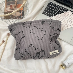 Macro detail of grey corduroy cosmetic bag featuring cute bear print and soft fabric texture