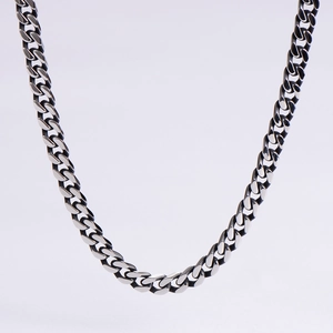 Macro detail of polished silver cuban link chain with reflective metallic texture