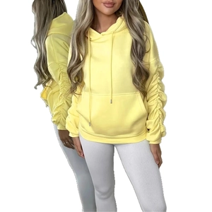 Close-up of bright yellow oversized hoodie featuring drawstring hood and pleated long sleeves