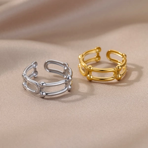 Macro shot of polished 18k gold and silver adjustable rings on luxury satin fabric