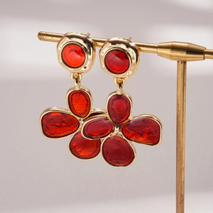 Detail of vintage gold-tone flower earrings with vibrant red drip oil enamel finish