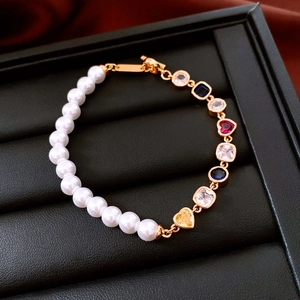 Détail macro du bracelet perles plaqué or 18K avec zircons colorés en forme de cœur