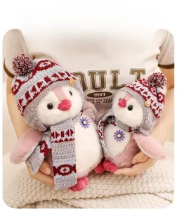 Close-up of fluffy pink and white penguin plush toys with knit hat and scarf set