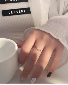 Detail of s925 silver V-shape ring with sparkling diamonds on an elegant model hand