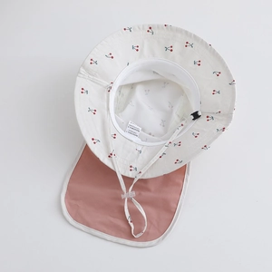 Detail of kids sun hat featuring cherry print, neck protection flap and adjustable chin strap