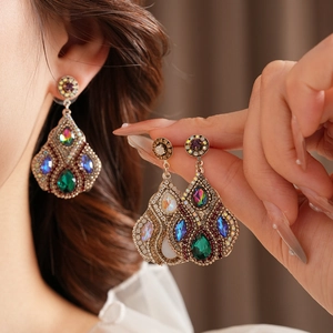 Détails de boucles d'oreilles vintage avec cristaux colorés et fini métal antique