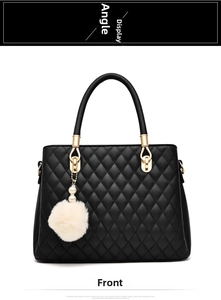 Front view of black quilted handbag with plush white pompom and pearl charm detail