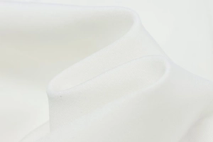 Detailed macro shot of high-density soft white knit fabric texture and smooth folds