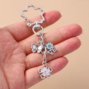 Silver metal keychain with butterfly and blue flower charms on a cherry blossom ring