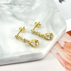 Detail of 925 sterling silver stamp on elegant gold-plated teardrop earrings with crystals