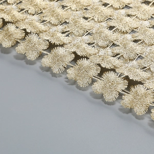 Detailed close-up of golden floral embroidery with intricate clover patterns and metallic finish