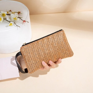Handmade woven straw clutch bag in light brown with a black wrist strap and zipper