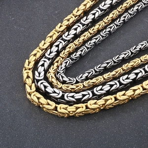 Detailed macro view of gold and black Byzantine chain necklaces with intricate woven links