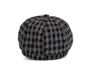 Dettaglio del retro di un cappello newsboy vintage a quadri con bordi sfrangiati