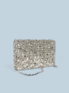 Macro detail of silver handmade beaded square bag featuring hollow metal geometric patterns