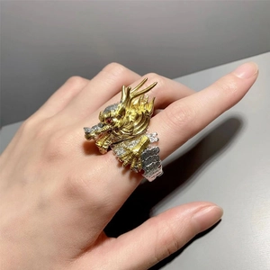 Detailed view of vintage gold dragon ring with intricate silver scales on finger