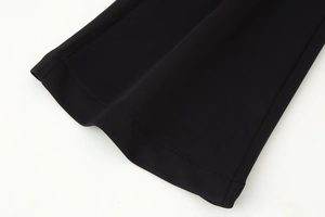 Close-up of high-quality stitching on the black flared trousers hem with clean finish