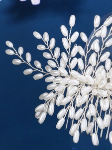 Detailed view of handmade silver wire hair comb with white pearls in leaf pattern