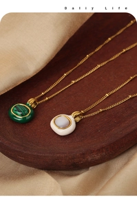 Detail of titanium steel necklaces with green malachite and white shell pendants