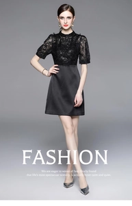 Detail view of a black lace patchwork dress with heavy beadwork and sequins on the bodice
