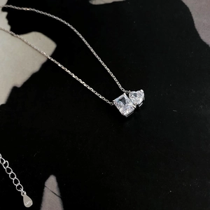 Detail of S925 silver necklace with emerald and heart cut cubic zirconia pendants