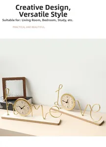 Detail of creative 'HOME' and 'LOVE' gold metal wire desk clocks with wooden base
