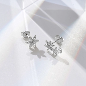 Detail view of asymmetric s925 silver flower earrings with zircons and rainbow prism light