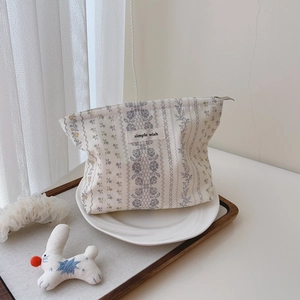 Detailed close-up of floral cotton cosmetic bag with zipper and simple wish label