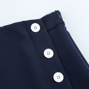 Detail of navy blue skirt waist with side invisible zipper and white button accents