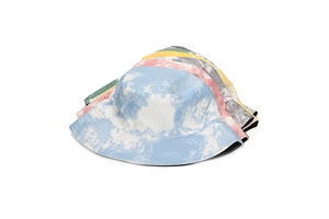 Close-up of stacked colorful tie-dye canvas bucket hats showing vibrant summer patterns