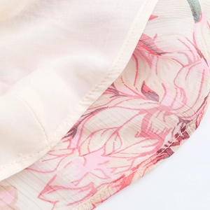 Detail view of floral chiffon fabric with elegant pink flower patterns and fine stitching