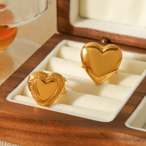 Dettaglio di anelli a cuore in acciaio inossidabile 18K con motivi lisci e floreali vintage