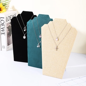 Modern velvet and linen portrait necklace display stands in black, green, and beige