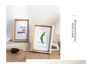 Detailed view of dual-tone wooden frames with botanical art on a cozy desktop