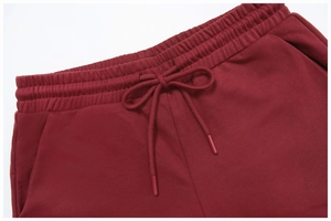 Detail of dark red knit shorts featuring elastic waistband and matching drawstring finish