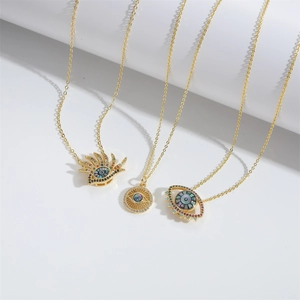Three creative golden evil eye necklaces with colorful zircon stones in minimalist flat lay
