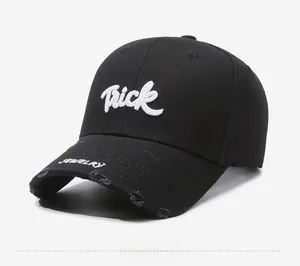 Close-up of black distressed baseball cap with Trick embroidery and torn brim detail