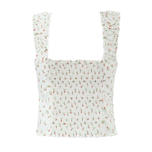 Detail of white floral crop top with red roses, smocking craft, and ruffled straps