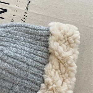 Close-up of gray knitted wool hat with thick faux fur trim and soft autumn texture