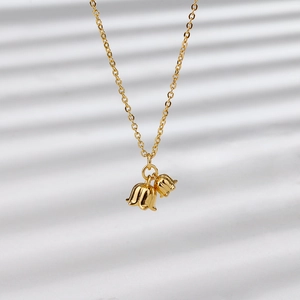 Close-up of gold-plated lily of the valley necklace with twin flower pendants on a thin chain