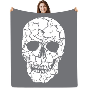 Detail of grey flannel blanket featuring a large white cracked skull digital print design