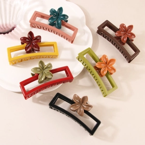 Dettaglio di fermagli per capelli con fiori multicolore in varie tonalità su vassoio