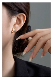 Detail of vintage French rose earrings with white petals and gold leaf on earlobe