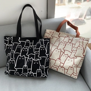Detail of canvas tote bags featuring cute minimalist cat patterns on black and white fabric