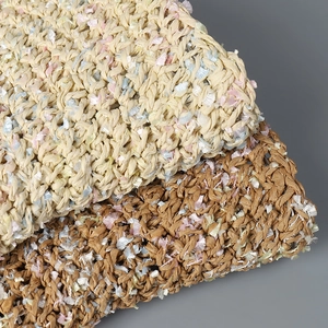 Handwoven summer straw hat for women with colorful yarn accents and textured beige finish