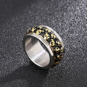 Macro detail of rotating punk skull ring in silver and gold stainless steel finish