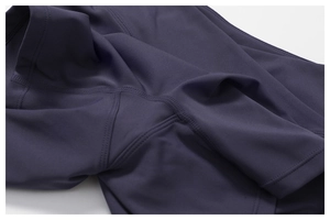 Détail des coutures plates professionnelles sur le tissu du short de yoga violet