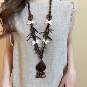Ethnic coconut shell necklace with wood beads, flower shells and leaf pendant