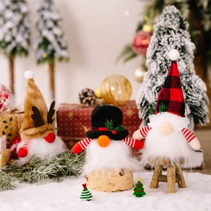 Three illuminated Christmas Gnomes with reindeer antlers and plaid hats on snowy background