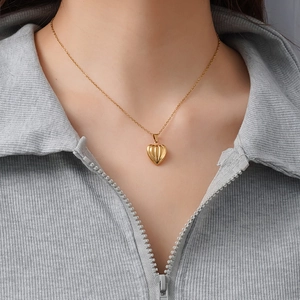 Golden titanium steel necklace with heart pumpkin pendant on a model neck